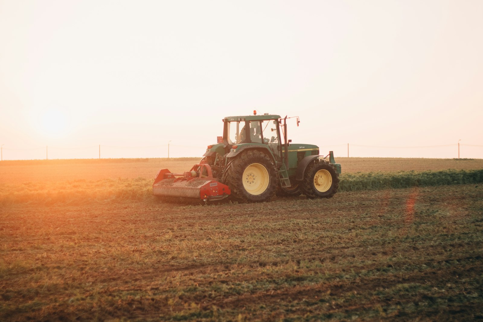 Tractor preparando suelo al atardecer